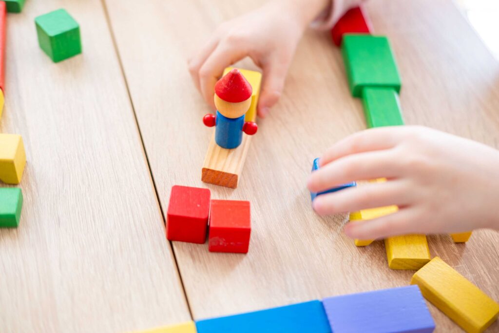 Kind speelt met gekleurde houten blokken