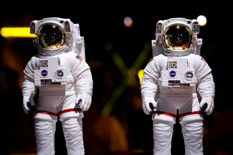 Ruimte speelgoed 6 jaar toont twee astronautenfiguren in witte ruimtepakken met helmen tegen een donkere achtergrond.